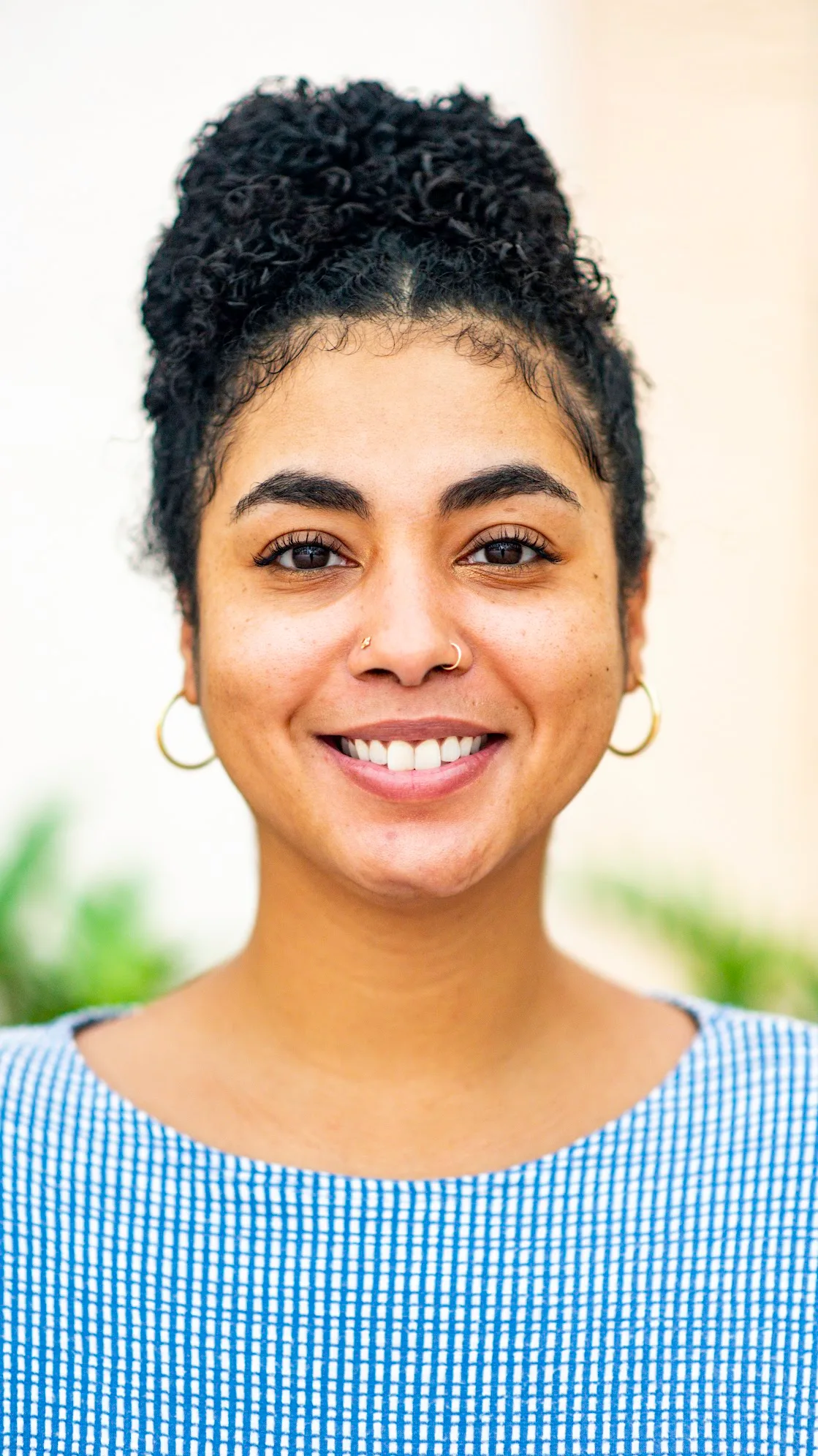 Portrait of Areshika Stephens smiling, wearing a light blue top against a white background