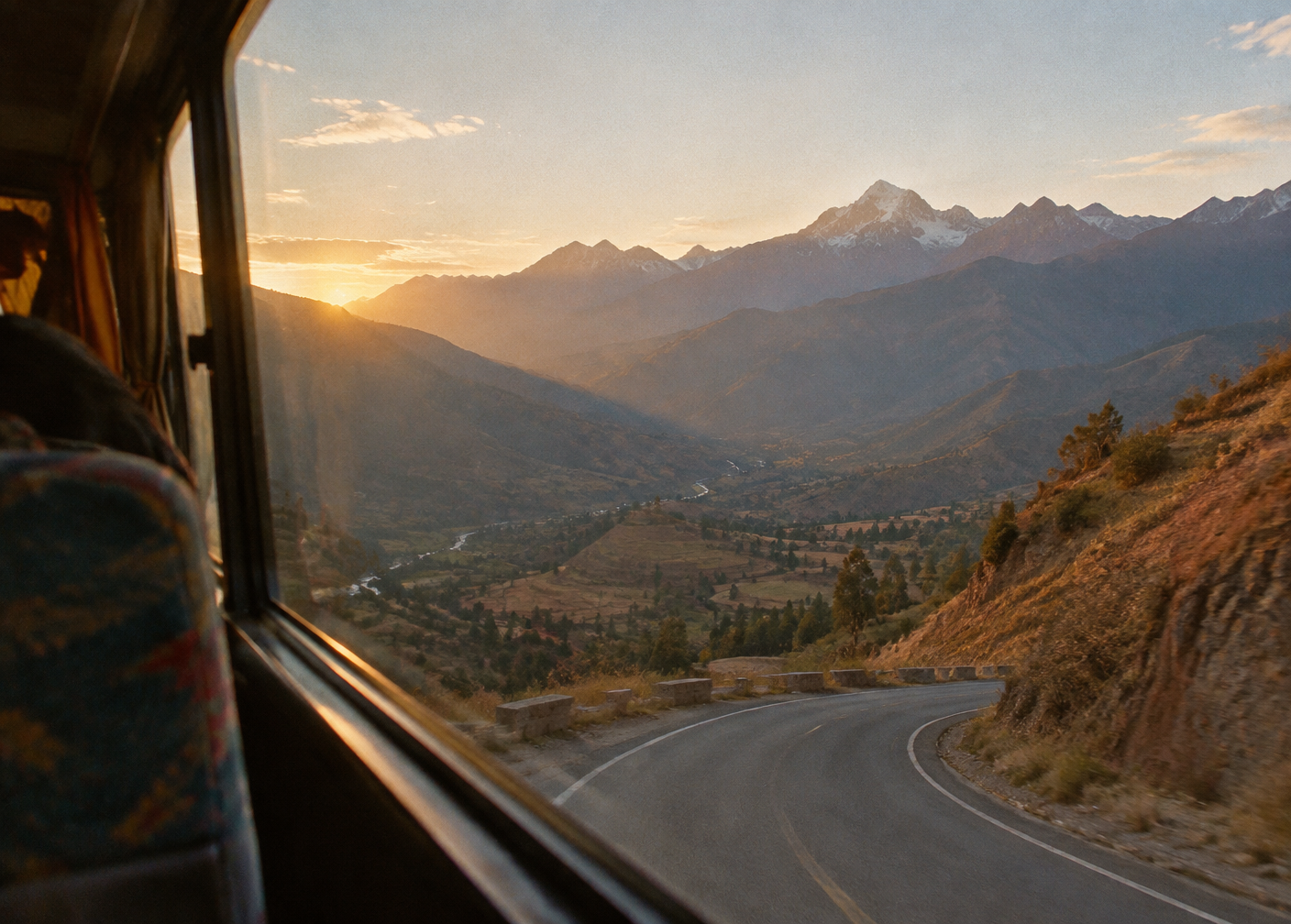 Andean mountain road at dawn seen from a bus window